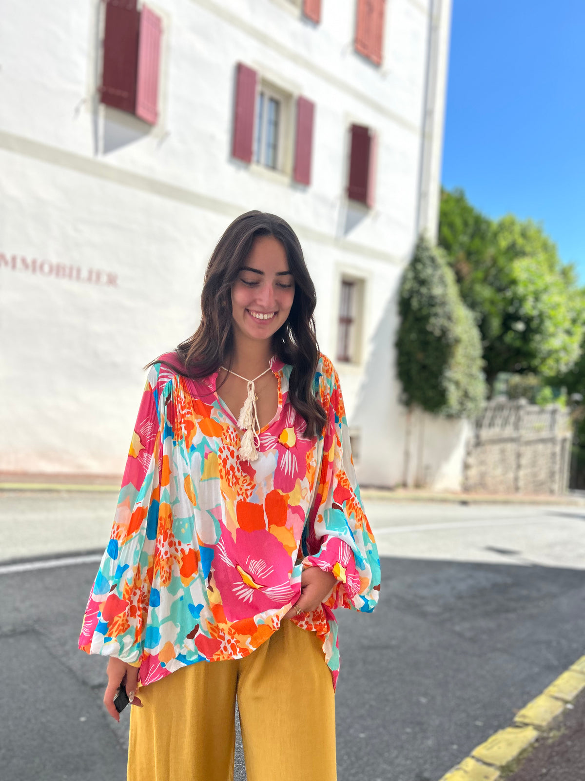 Blouse florale manches ballon, imprimé fleurs multicolores rose orange bleu, portée avec un pantalon large moutarde
