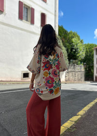 Blouse florale bohème vue de dos, imprimé fleurs multicolores, portée avec un pantalon large terracotta