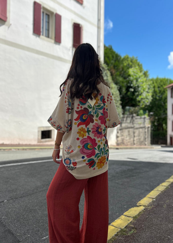 Blouse florale bohème vue de dos, imprimé fleurs multicolores, portée avec un pantalon large terracotta
