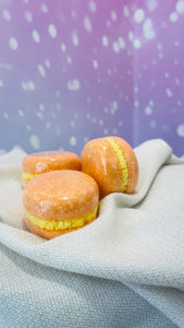  Macaron de bain effervescent orange, parfum pêche, étiquette ingrédients visible.