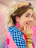 Zoom sur des boucles fantaisie rose vif tressées en rafia