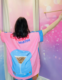 Modèle portant une chemise vintage oversize "Peace & Love" avec imprimé coloré bleu, rose et blanc, et manches contrastantes.