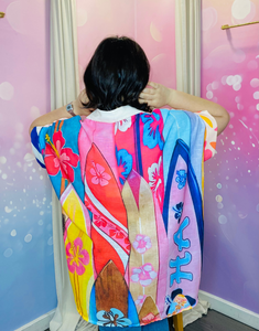Vue arrière de la chemise vintage "Ibiza Summer", montrant des motifs de palmiers et de planches de surf. Les couleurs chaudes et tropicales créent un look estival parfait pour les vacances ou les journées ensoleillées.