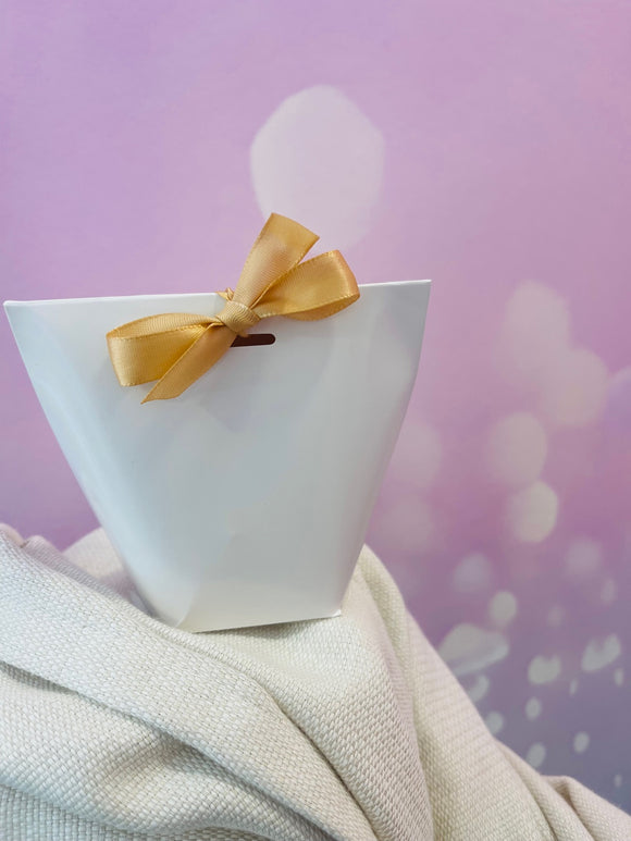 Coffret cadeau blanc avec nœud doré sur fond rose – coffret surprise féminin et raffiné, idée cadeau élégante et mystérieuse.