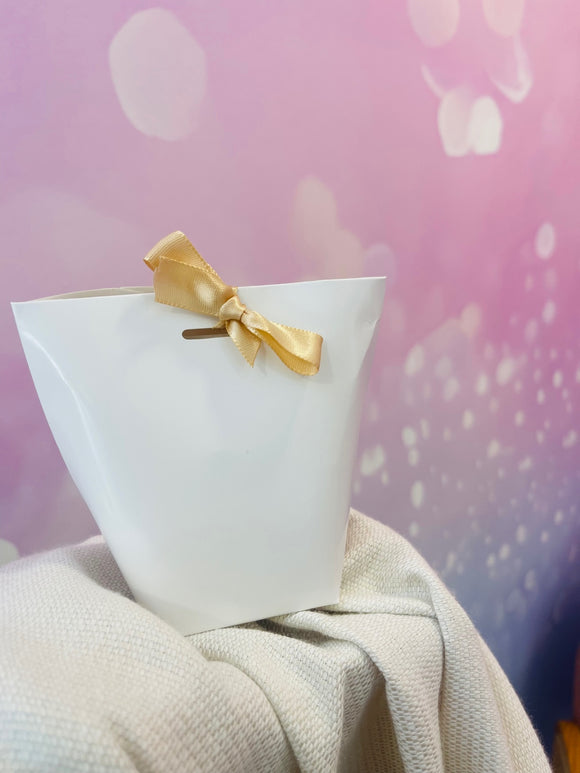 Coffret cadeau blanc avec ruban doré, ambiance chic et lumineuse – surprise féminine et raffinée, parfaite pour la Fête des Mères ou un moment précieux.