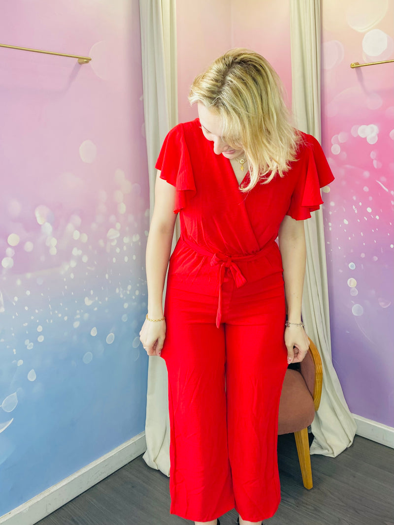 Combinaison pantalon à manches courtes volantées, avec un col cache-coeur et une taille ceinturée qui souligne la silhouette. La coupe fluide et droite offre un confort optimal tout en restant élégante. La combinaison est rouge mais il existe différents coloris. Cette pièce est idéale pour un look chic et décontracté. Egalement pour les jours de fêtes : un baptême, un mariage, une soirée mais aussi pour tous les jours. Belle idée cadeau.
