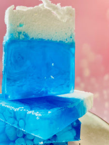 Savon artisanal bleu translucide avec mousse blanche, ambiance fraîche et marine