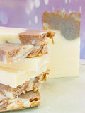 Savons artisanaux à la cannelle et au lait de chèvre empilés sur assiette, marbrures brunes et blanches